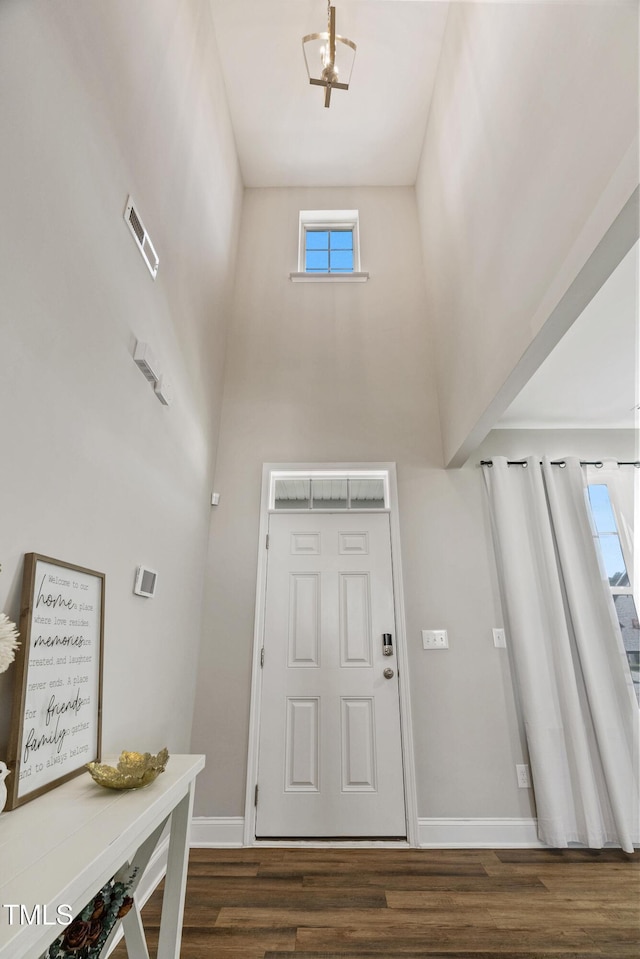 foyer entrance featuring a high ceiling and dark wood-type flooring