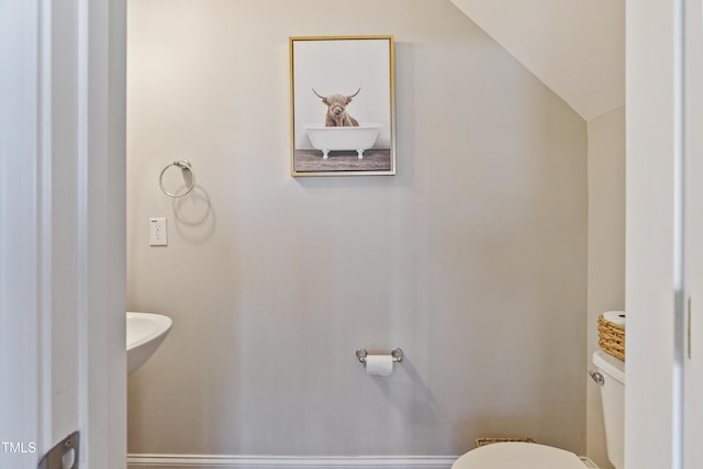 bathroom with lofted ceiling and toilet