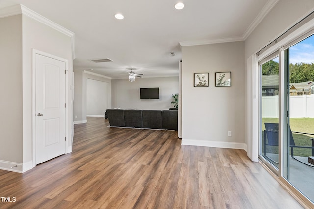 unfurnished living room with hardwood / wood-style flooring, ornamental molding, and ceiling fan
