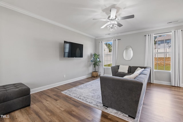 living room featuring dark hardwood / wood-style flooring, crown molding, a wealth of natural light, and ceiling fan