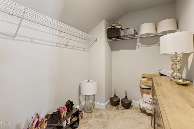 walk in closet featuring lofted ceiling and carpet