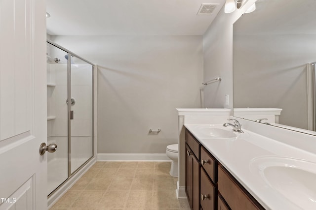 bathroom featuring a shower with door, vanity, tile patterned floors, and toilet