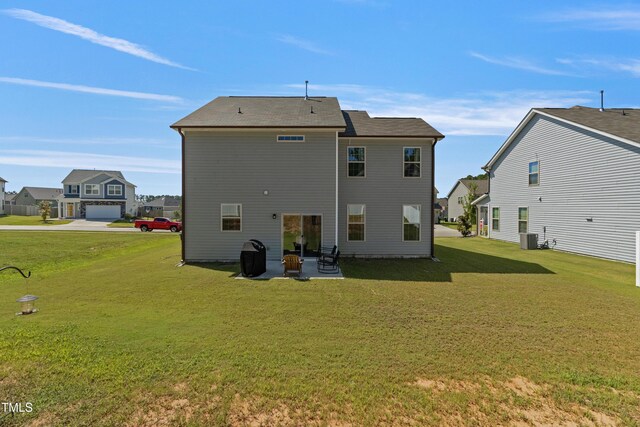 rear view of property featuring a yard, a patio area, and central air condition unit