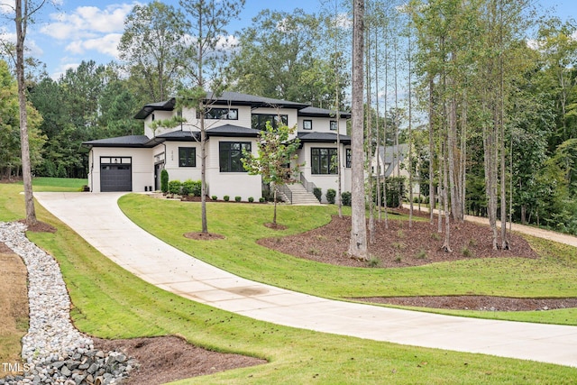 prairie-style home with an attached garage, concrete driveway, and a front yard