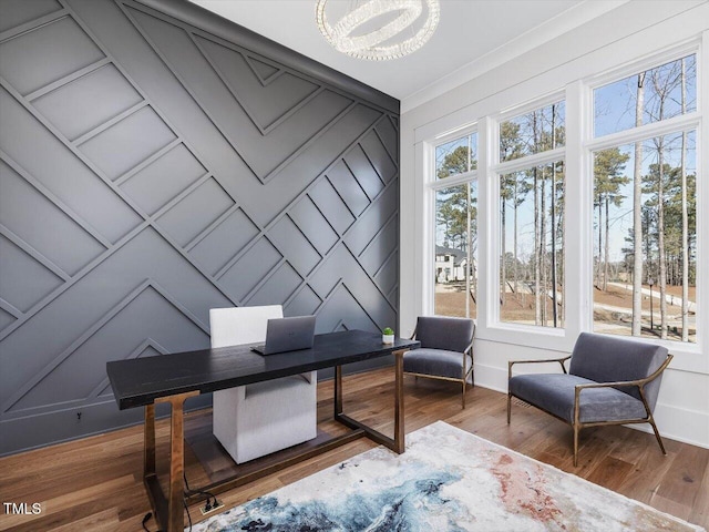 office area featuring baseboards, wood finished floors, a wealth of natural light, and a decorative wall