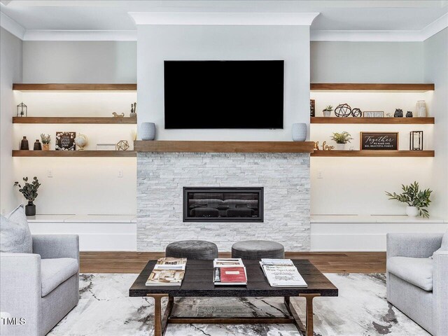 living room featuring a fireplace, ornamental molding, and wood finished floors