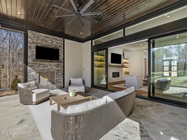 view of patio with an outdoor living space with a fireplace and ceiling fan