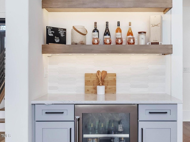 bar featuring beverage cooler, a dry bar, log walls, and decorative backsplash