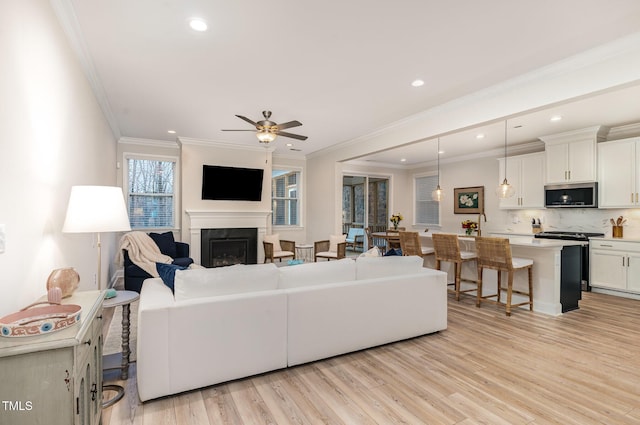 349 Shadow Falls Dr, Wendell, NC 27591 - living room with light wood-type flooring, a fireplace, recessed lighting, a ceiling fan, and ornamental molding