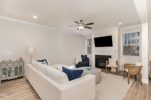 349 Shadow Falls Dr, Wendell, NC 27591 - living area featuring a glass covered fireplace, light wood-style floors, a ceiling fan, ornamental molding, and recessed lighting