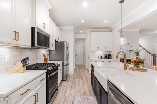 349 Shadow Falls Dr, Wendell, NC 27591 - kitchen featuring appliances with stainless steel finishes, a sink, light countertops, light wood-style flooring, and crown molding