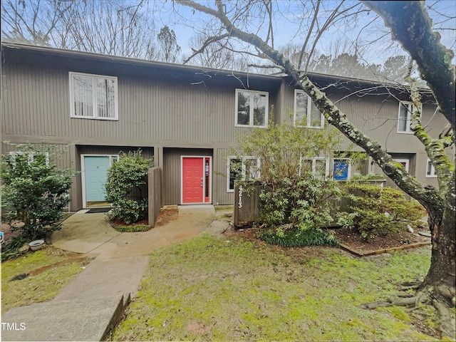 view of property with a garage, driveway, and a front lawn