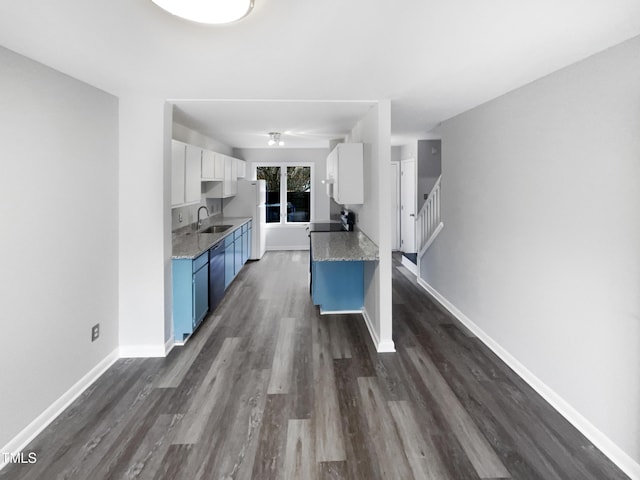 kitchen featuring sink, dark hardwood / wood-style floors, white refrigerator, white cabinets, and blue cabinets