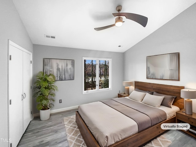 bedroom with vaulted ceiling, light hardwood / wood-style floors, and ceiling fan