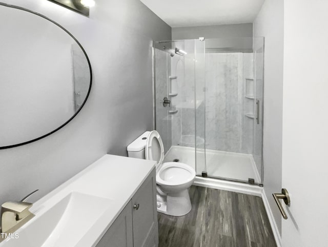 bathroom featuring vanity, hardwood / wood-style floors, an enclosed shower, and toilet