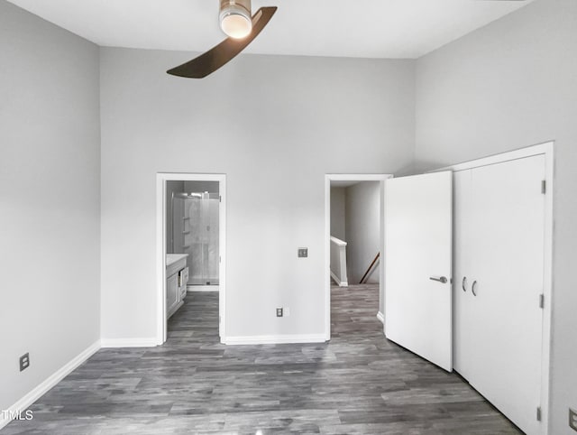 unfurnished bedroom with ensuite bathroom, ceiling fan, dark hardwood / wood-style flooring, and a closet