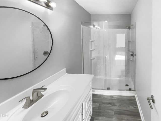 bathroom featuring vanity, a shower with door, and wood-type flooring