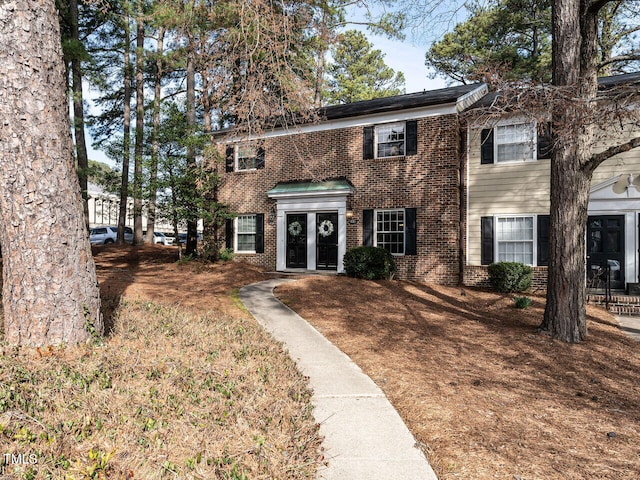 colonial inspired home featuring brick siding