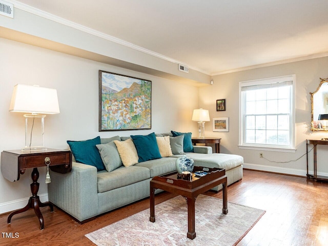 living room featuring ornamental molding, wood finished floors, and visible vents