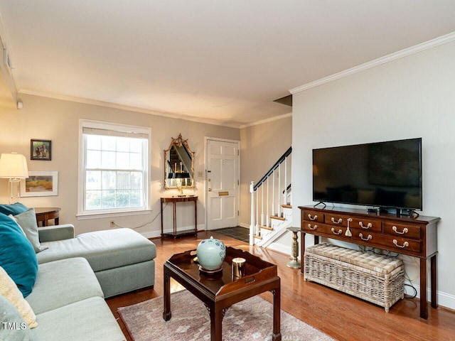 living room featuring baseboards, stairway, wood finished floors, and ornamental molding