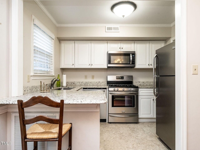 kitchen featuring stainless steel appliances, a peninsula, visible vents, white cabinets, and a kitchen bar