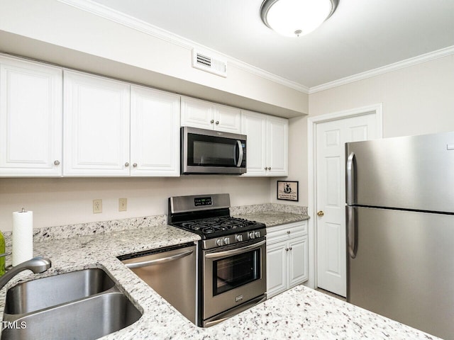 kitchen with crown molding, visible vents, appliances with stainless steel finishes, white cabinetry, and a sink