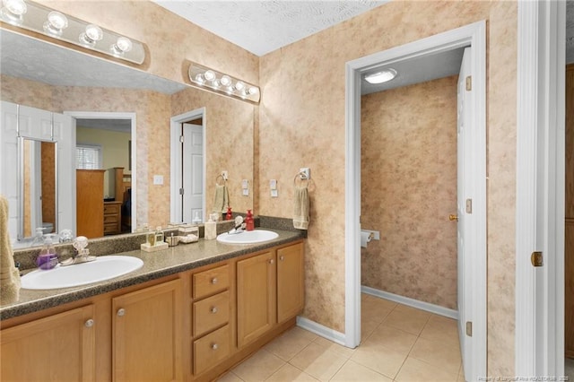 bathroom featuring vanity, tile patterned floors, and a textured ceiling