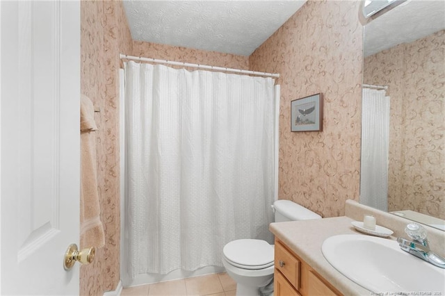 bathroom featuring vanity, tile patterned floors, toilet, and a textured ceiling