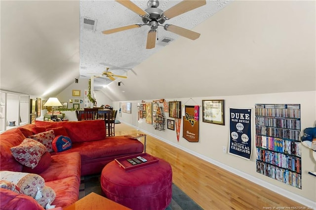 living room with lofted ceiling, hardwood / wood-style flooring, and a textured ceiling