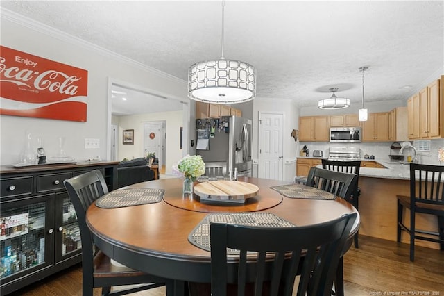 dining room with crown molding, sink, a textured ceiling, and dark hardwood / wood-style flooring