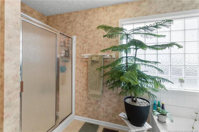 bathroom with tile patterned flooring, an enclosed shower, and a textured ceiling