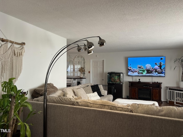 living room with a textured ceiling and a fireplace