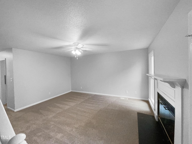 unfurnished living room with carpet, a textured ceiling, and ceiling fan