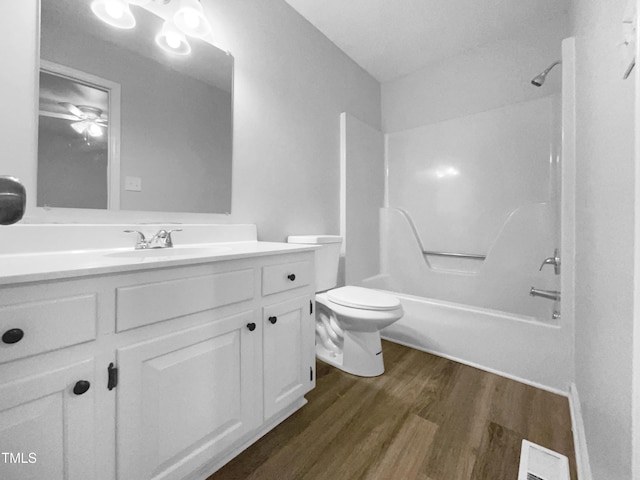 full bathroom featuring wood-type flooring, bathing tub / shower combination, vanity, and toilet