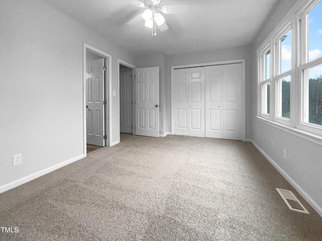 unfurnished bedroom featuring carpet floors, ceiling fan, and a closet