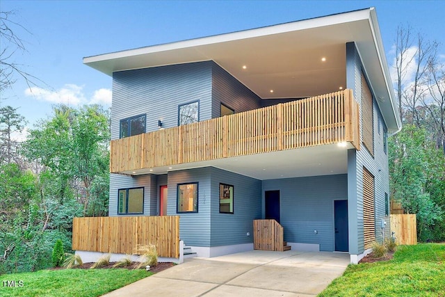 rear view of house featuring a carport and a balcony