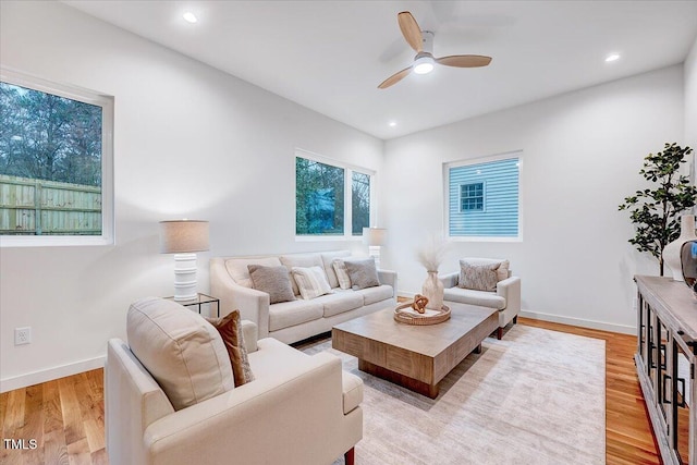 living room with light hardwood / wood-style flooring and ceiling fan