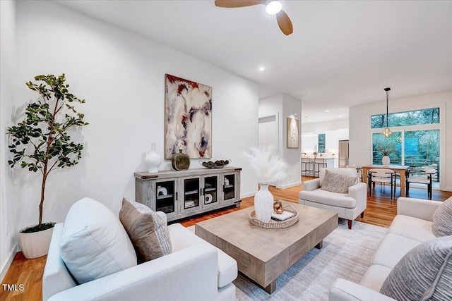 living room with ceiling fan and light hardwood / wood-style floors