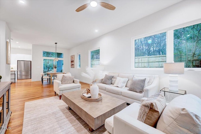 living room featuring ceiling fan and light hardwood / wood-style floors