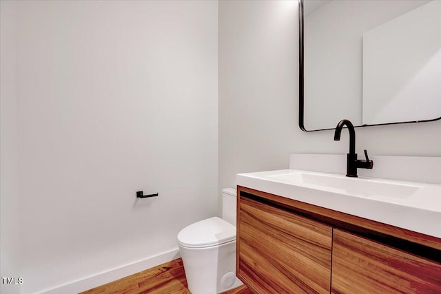 bathroom with vanity, hardwood / wood-style floors, and toilet