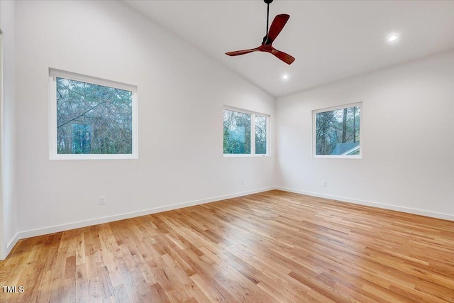 spare room with ceiling fan, vaulted ceiling, and light wood-type flooring