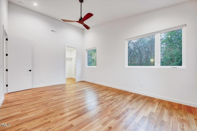 unfurnished bedroom with a walk in closet, light hardwood / wood-style flooring, and ceiling fan