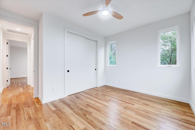 unfurnished bedroom featuring light hardwood / wood-style floors, a closet, and ceiling fan