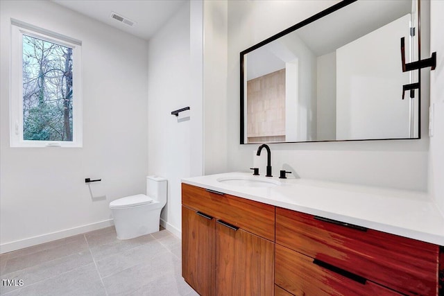 bathroom with tile patterned flooring, vanity, and toilet