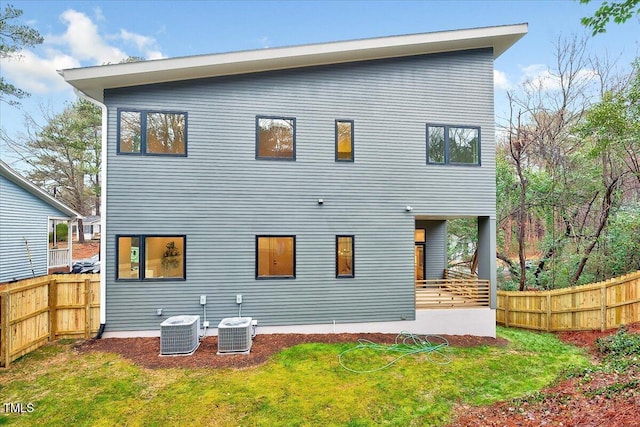 rear view of property with a yard and central AC