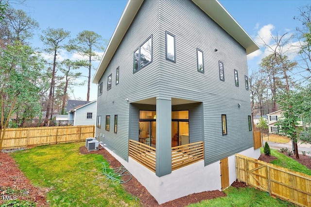 rear view of house with a yard and central air condition unit