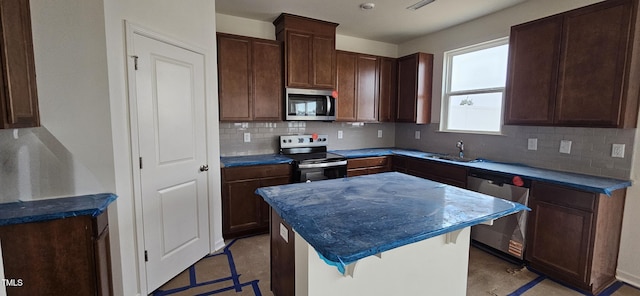 kitchen featuring sink, a breakfast bar area, a kitchen island, stainless steel appliances, and backsplash