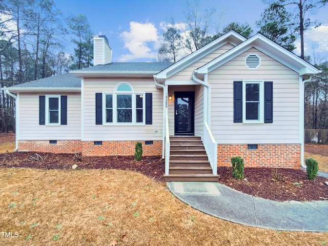 ranch-style home with roof with shingles, crawl space, a chimney, and a front yard