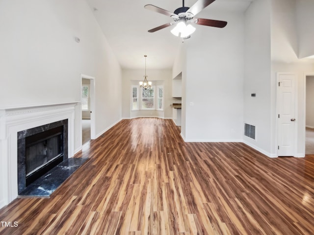 unfurnished living room featuring a premium fireplace, dark wood finished floors, and visible vents