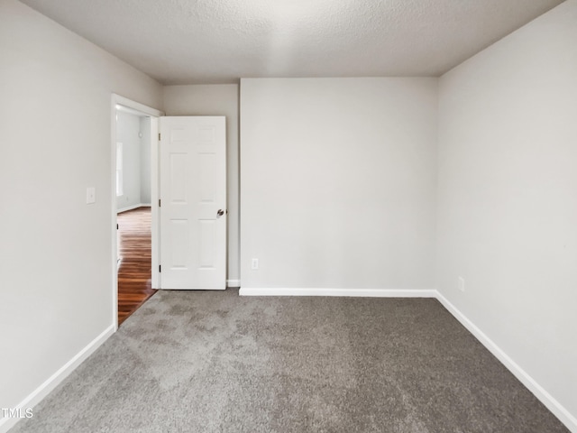 carpeted empty room featuring a textured ceiling